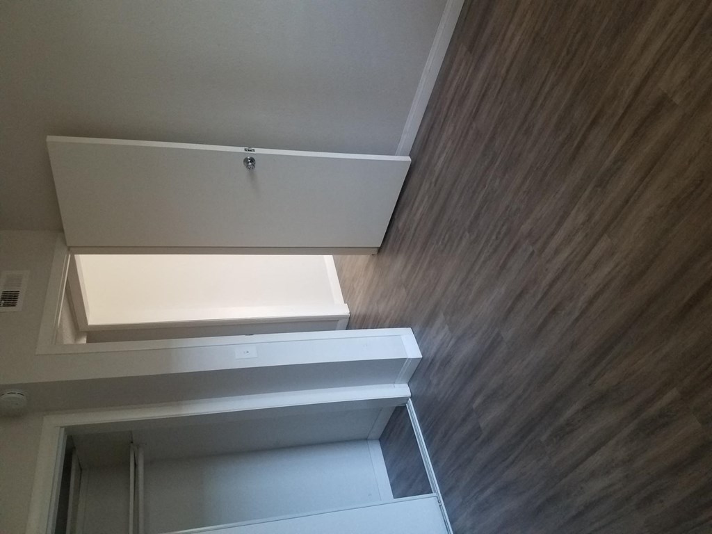 Bedroom with hardwood flooring and large closet at Tulip Street Apartments in Escondido, California.
