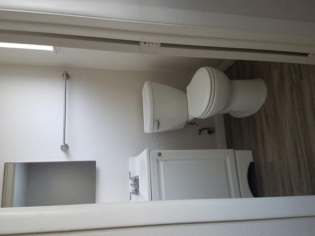 Bathroom with white cabinets and fixtures at Tulip Street Apartments in Escondido, California.