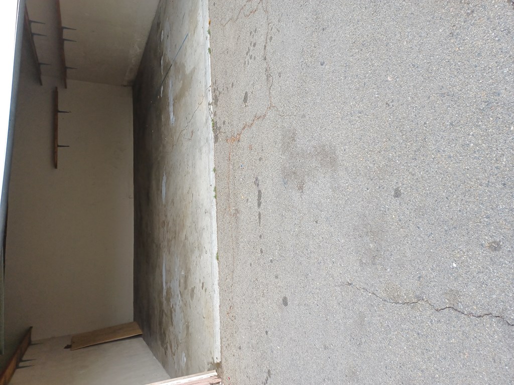 Wide garages with wall shelves at Juniper Street Apartments in Escondido, California.