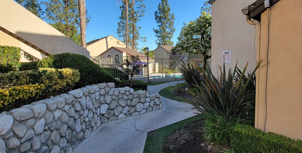 Beautifully landscaped walkway to one of the pools at Northwood Apartments in Upland, California.