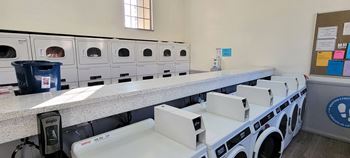 a row of washers and dryers in a laundry room