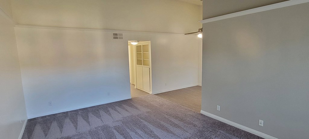 Living room view of dining room and hallway with storage space at Northwood Apartments in Upland, California.