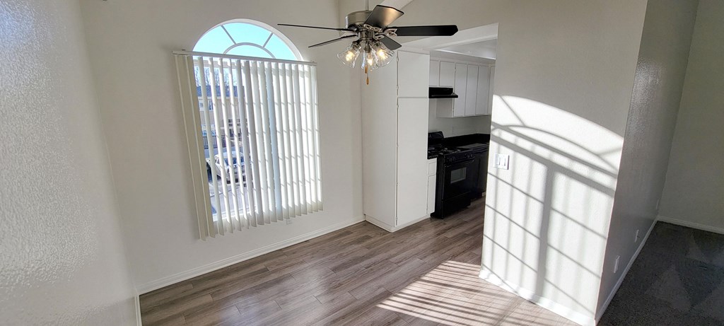 Dining room with beautiful window and ceiling fan at Northwood Apartments in Upland, California.