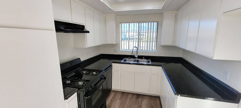 Kitchen with lots of natural light and cabinet space at Northwood Apartments in Upland, California.