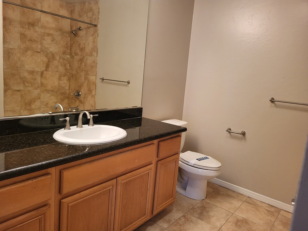 Master bedroom bathroom with granite countertop and tile flooring at The Cove at Bear Valley in Escondido, California.