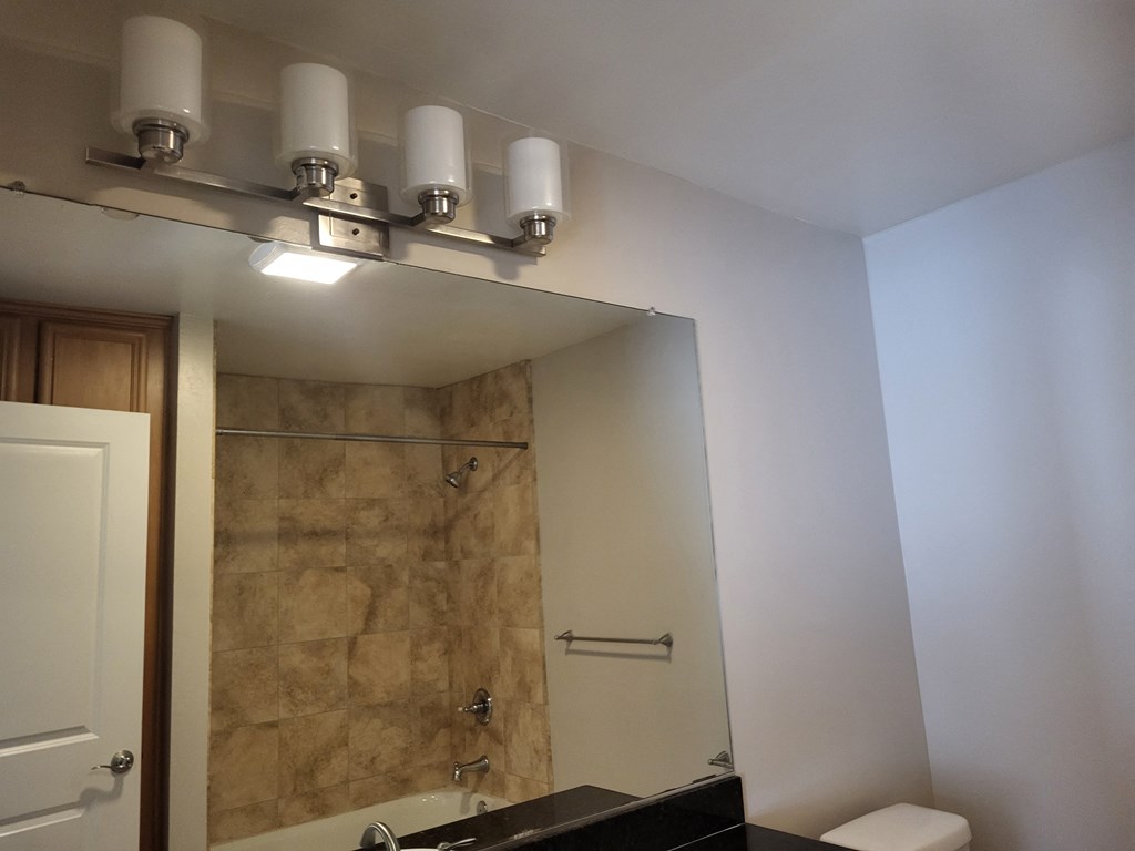 Bathroom with beautiful tile bath, large mirror and closets at The Cove at Bear Valley in Escondido, California.