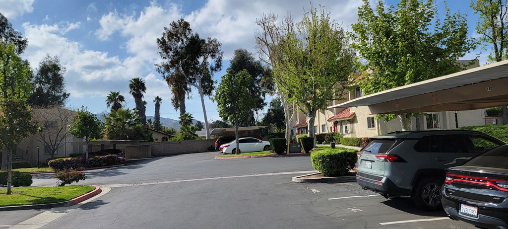 Assigned covered parking and lots of mature trees at Sierra Vista Apartment Homes in Lake Elsinore, California.