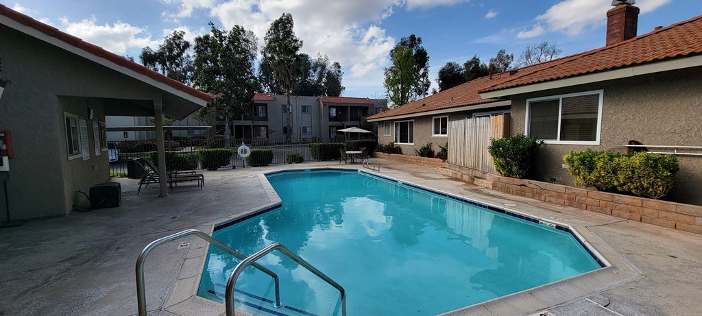 Crystal clear swimming pool and inviting sun deck at Sierra Vista Apartment Homes in Lake Elsinore, California.
