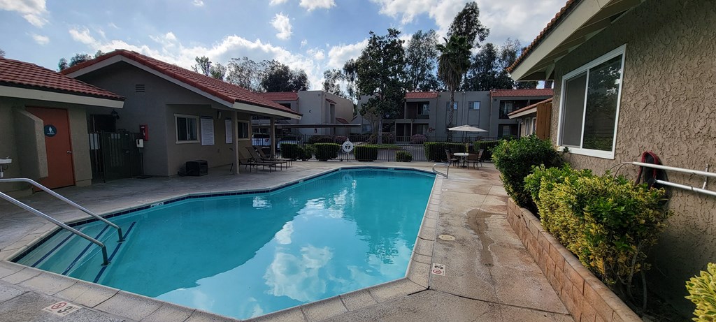 Gated swimming pool and sun deck at Sierra Vista Apartment Homes in Lake Elsinore, California.