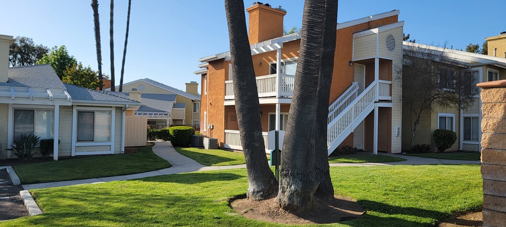 Mature trees and manicured lawns surround apartments at The Cove at Bear Valley in Escondido, California.