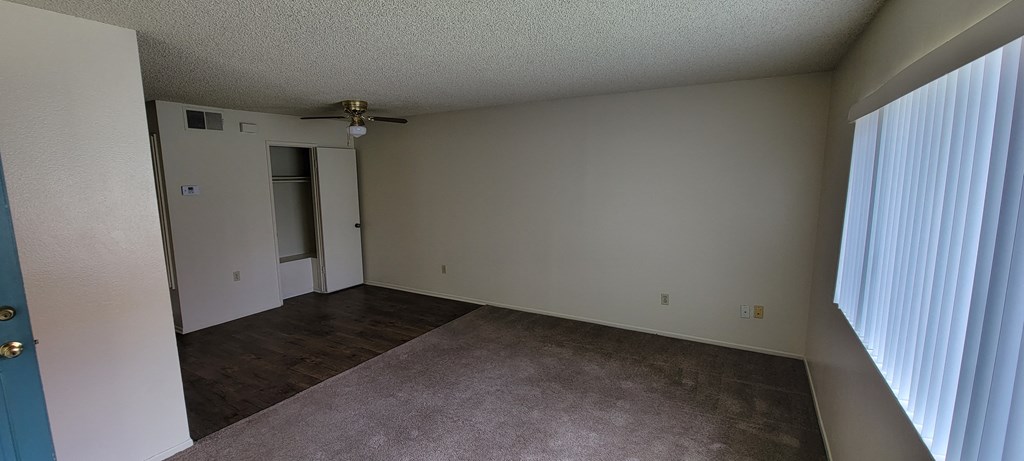 Living room and dining room area with large front window at Magnolia Apartments in Riverside, California.