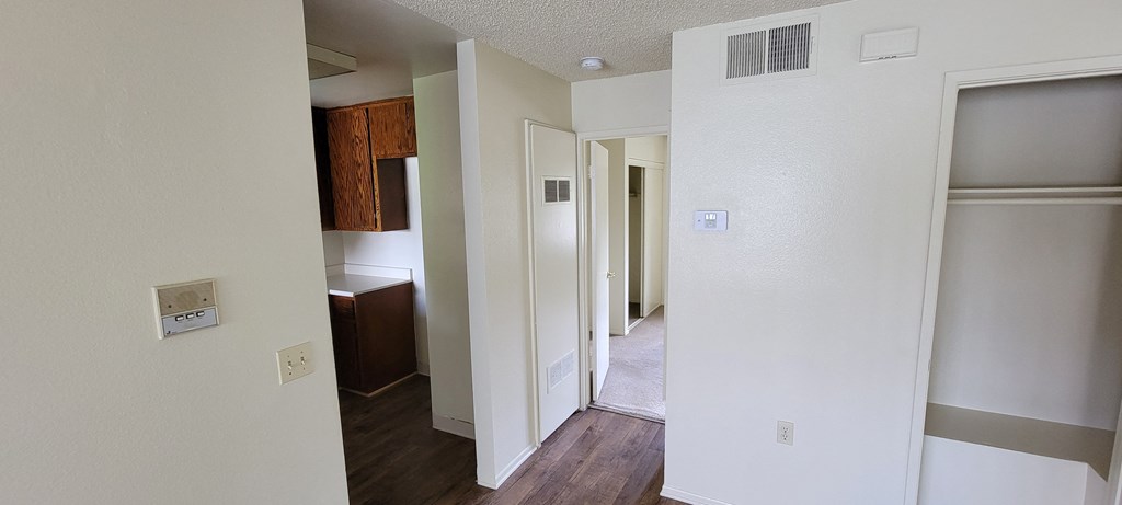 Front room view of kitchen and hallway to bedrooms in unit at Magnolia Apartments in Riverside, California.