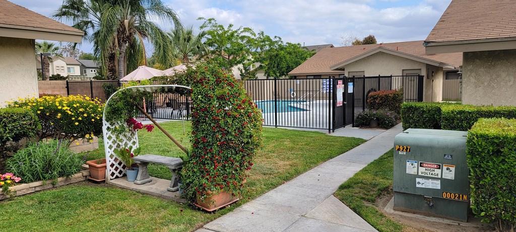 Serene sitting bench and entrance to swimming pool at Las Casitas Apartments in Riverside, California.