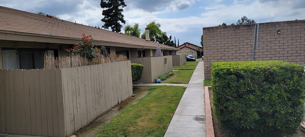Private patios along walkways to apartments at Las Casitas Apartments in Riverside, California.