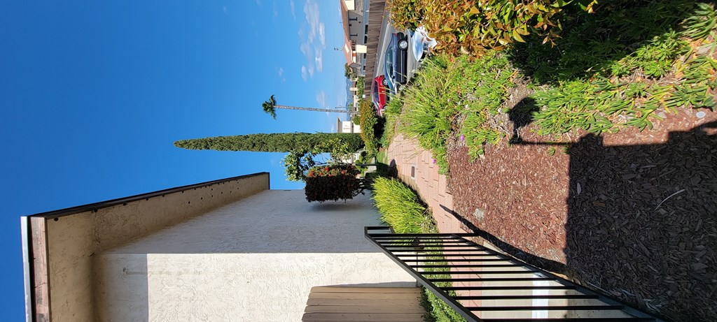 Paver walkway and gardens around apartment building at Plaza Verde Apartments in Escondido, California.