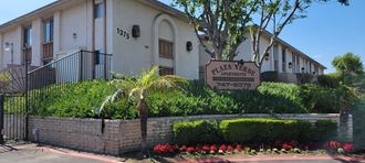 Gated front enterance with lush gardens at Plaza Verde Apartments in  Escondido, California.