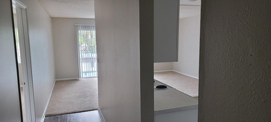 Entry hallway view of living room and kitchen at La Mesa Village Apartments in La Mesa, California.