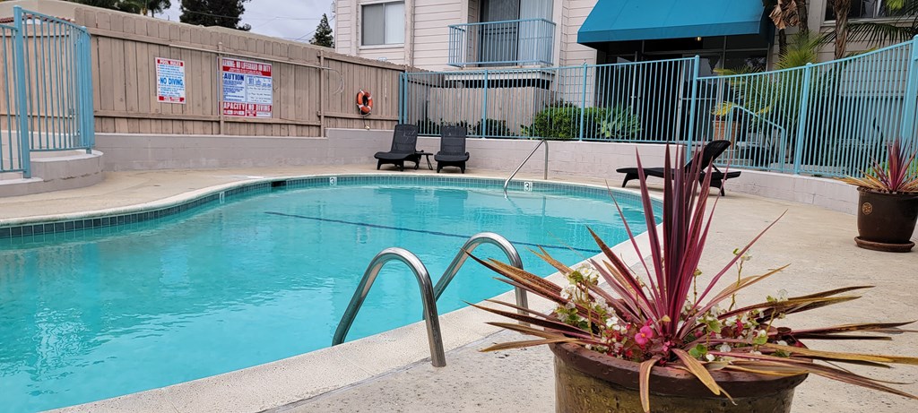 Swimming pool and chaise lounge chairs at La Mesa Village Apartments in La Mesa, California.
