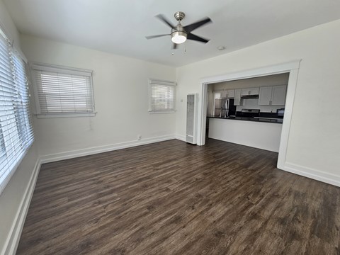 A room with a ceiling fan and wooden flooring.