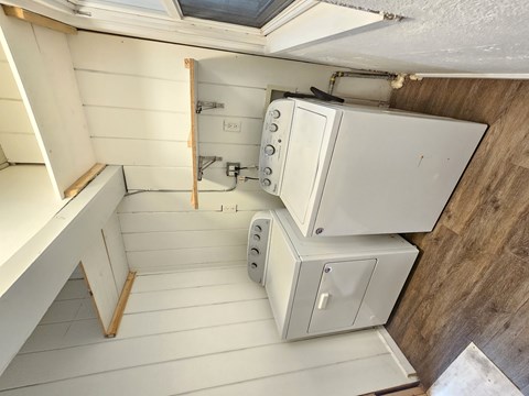 A small, white, compact kitchen with a stove and oven.