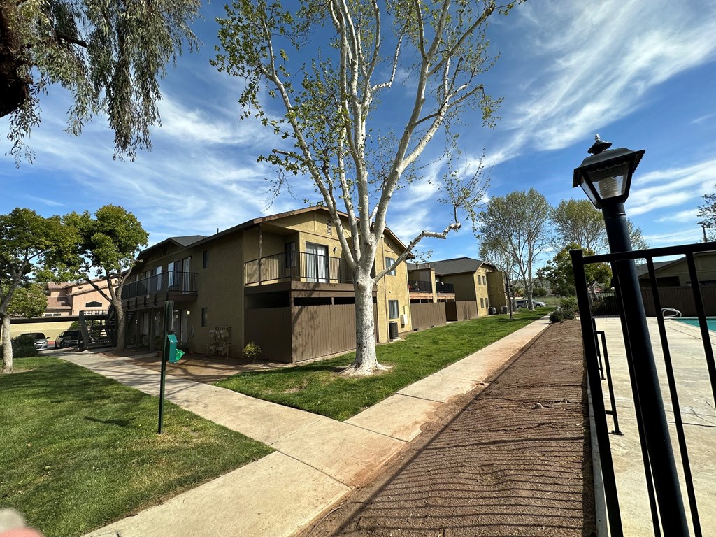 Mature trees along walkway at Riverdale Apartment Homes in Hemet, California.