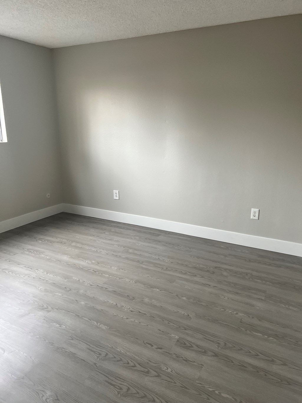 Living room with hardwood floors and natural light at IKARIA Apartments in Santee, California.