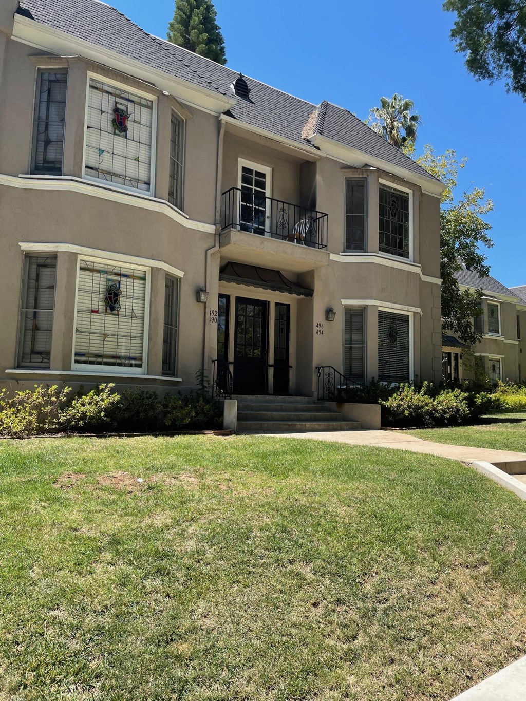 Front of property showing vintage stain glass in bay windows of Orange Grove Apartments in Pasadena, CA.