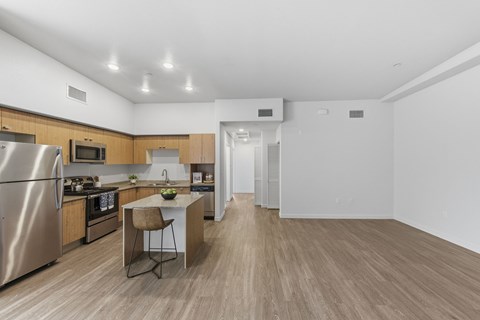 A kitchen with a refrigerator, microwave, and oven.