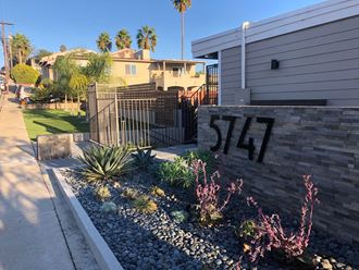 Sidewalk gated entrance to 5747 Lauretta Street Apartment in San Diego, California.