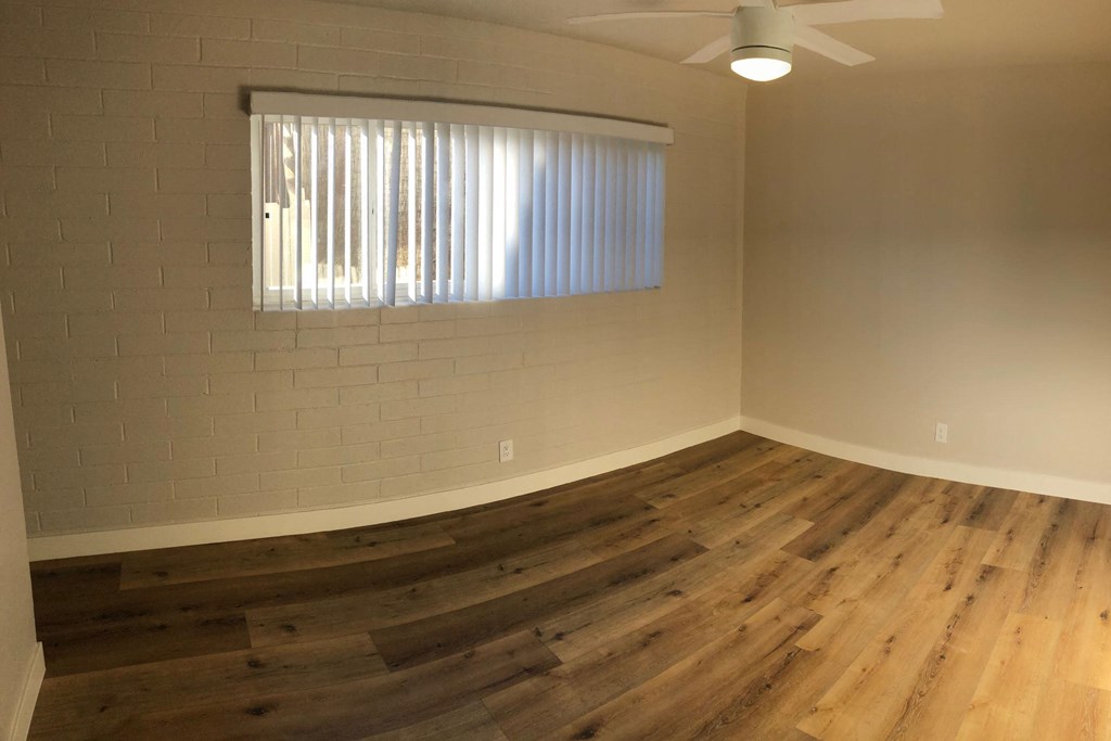 Dining room and living room area with wood plank style vinyl flooring at 5747 Lauretta Street Apartments in San Diego, California.