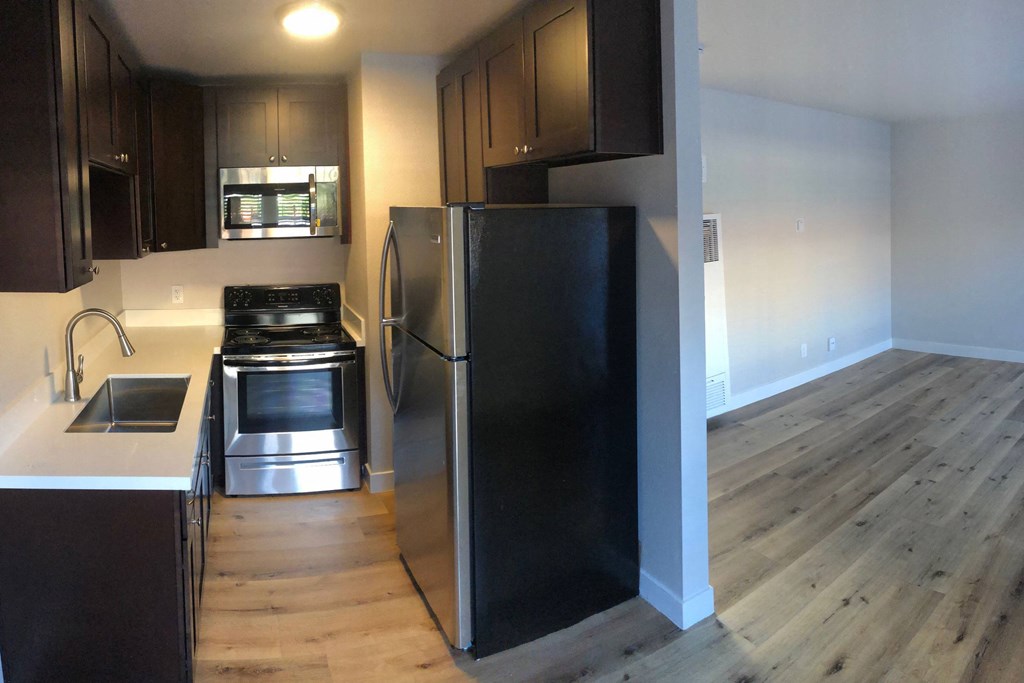 Kitchen with spacious wood stained cabinets and stainless steel appliances at 5747 Lauretta Street Apartments in San Diego, California.