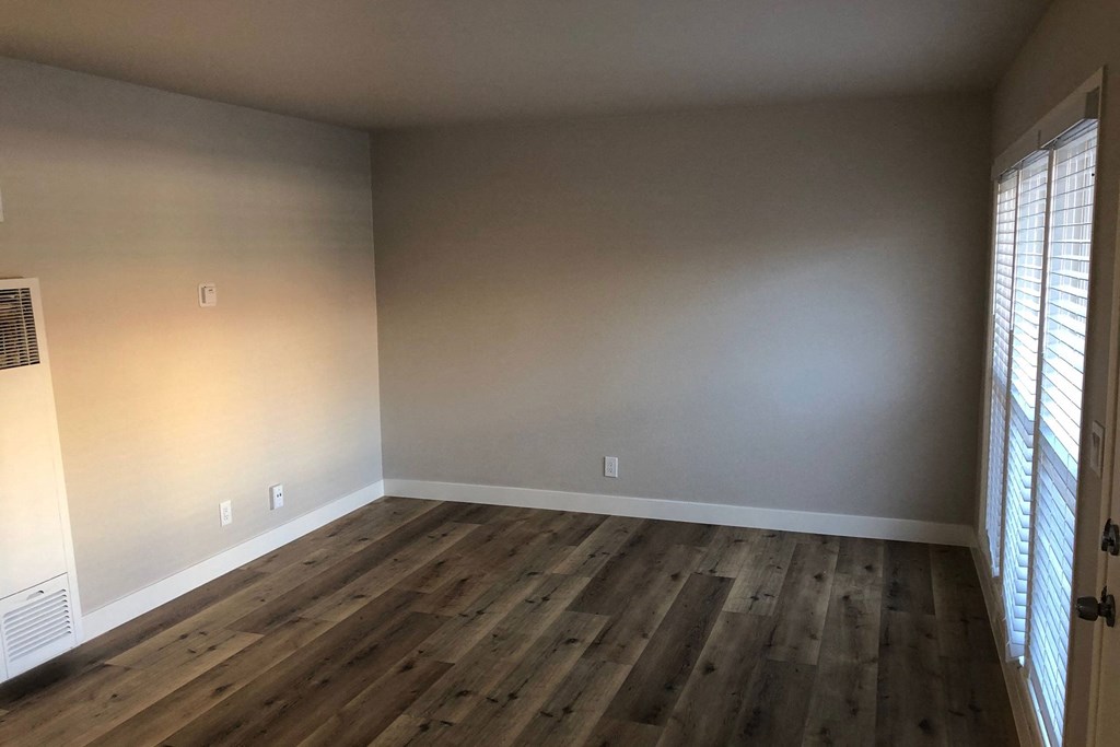 Living room with wood plank style vinyl flooring with lots of natural light at 5747 Lauretta Apartments in San Diego, California.