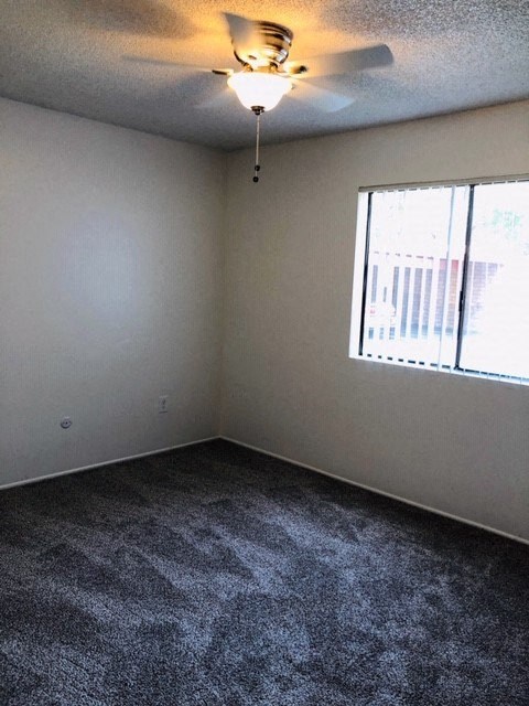 a room with a ceiling fan and a window