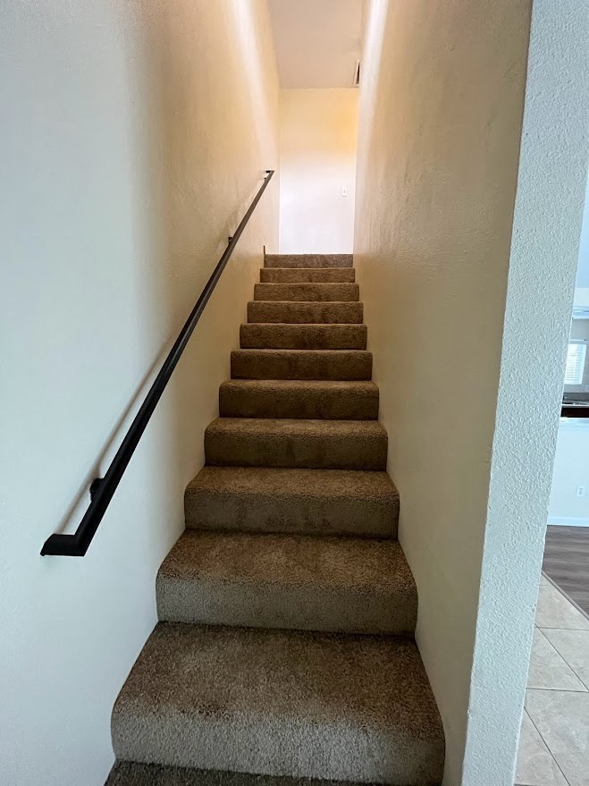 Carpeted stairway in 980 E Mission Avenue Apartments.