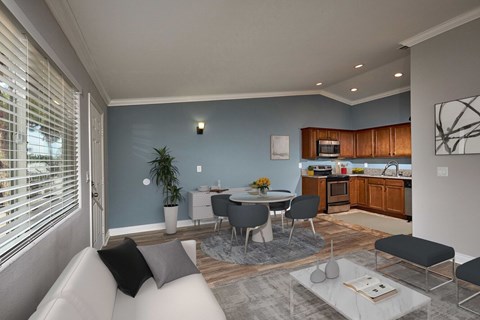 A modern living room with a grey sofa and a dining table set up.