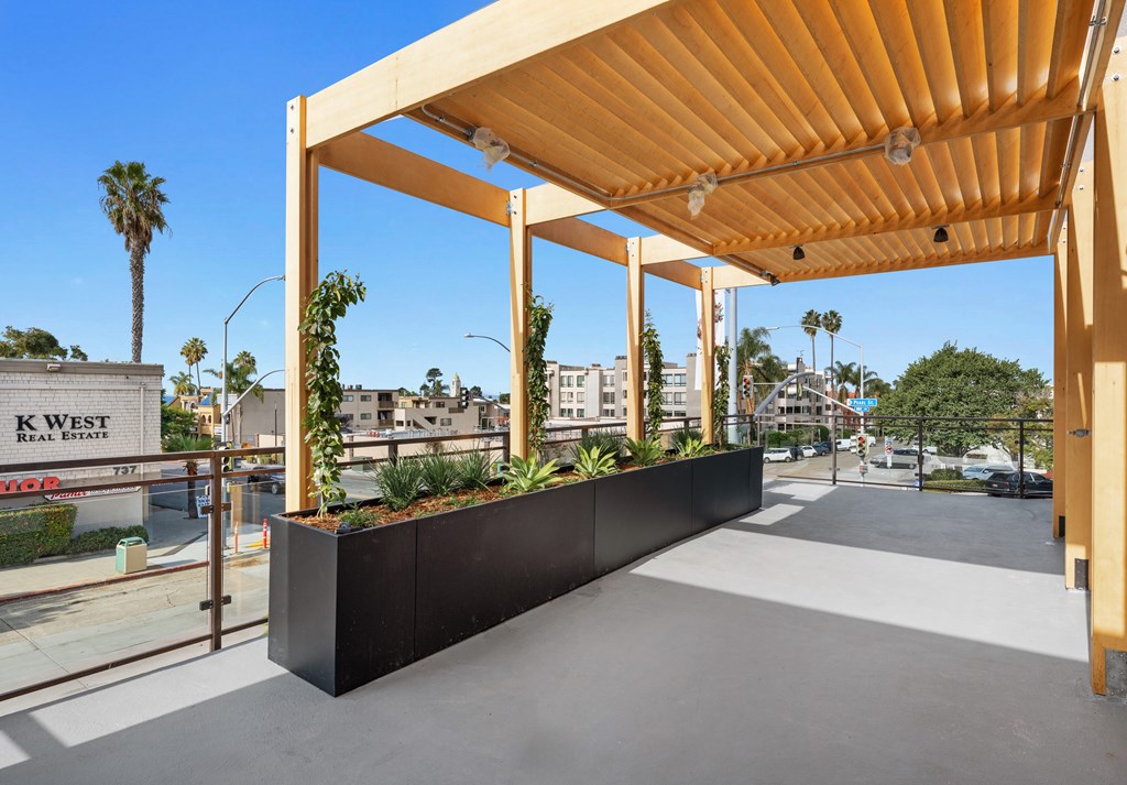 A wooden structure with a black planter box underneath it.