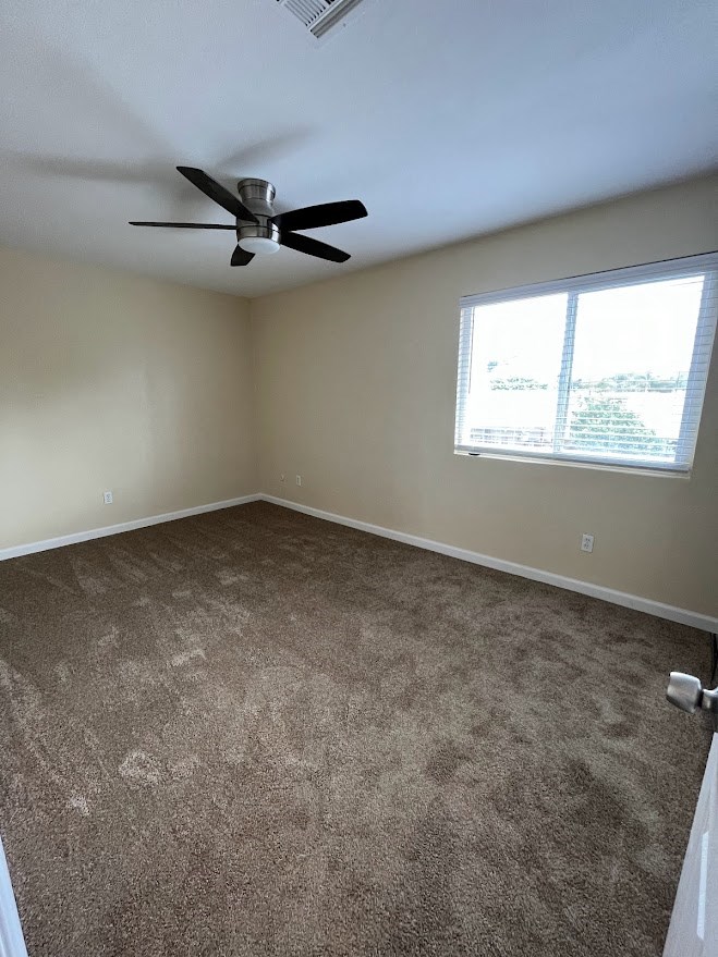 Bedroom with ceiling fan and large window at 980 E Mission Avenue Apartments in Escondido, CA.