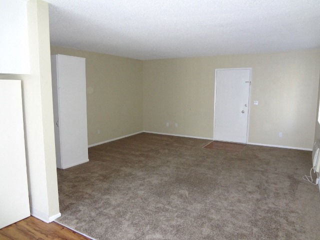 Carpeted living room at Villa Knolls Apartments in La Mesa, California.