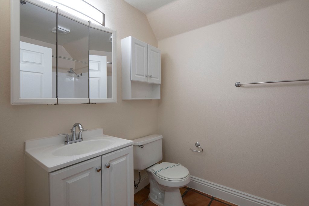 Bathroom with white fixtures and Saltillo flooring at the Atrium Apartments in San Diego, California.
