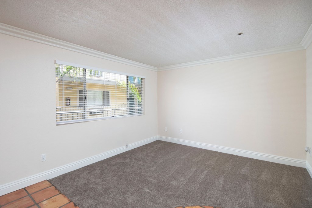 Front room with custom blinds over large window at the Atrium Apartments in San Diego, California.