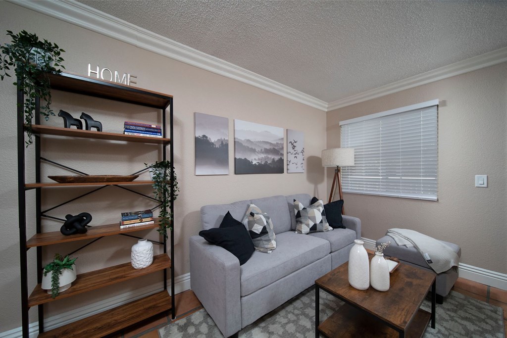 Living room in model unit with Saltillo tile floors, crown molding, and custom window binds at the Atrium Apartments in San Diego, California.