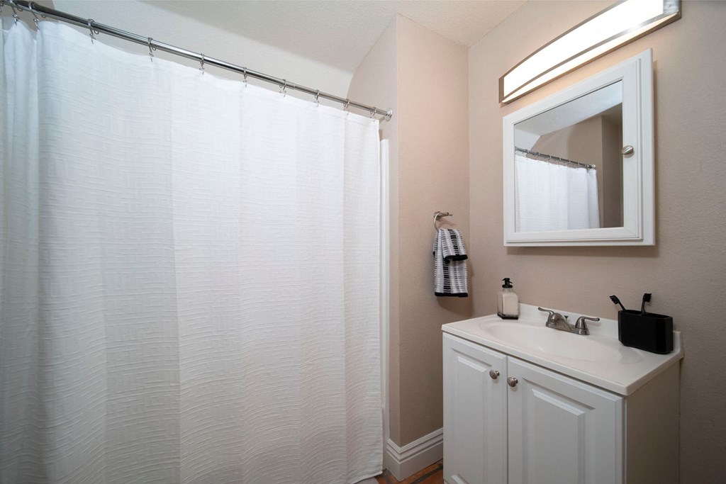 Model unit bathroom with white fixtures at the Atrium Apartments in San Diego, California.