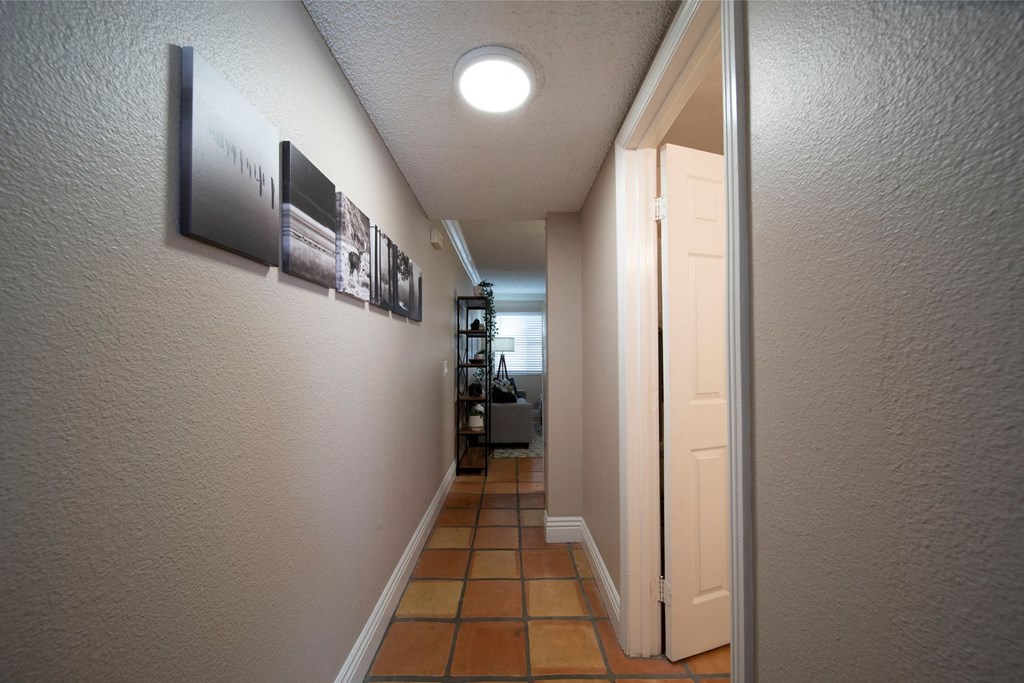 Model Unit showing Saltillo tiled flooring in bedroom hallway at the Atrium Apartments in San Diego, California.