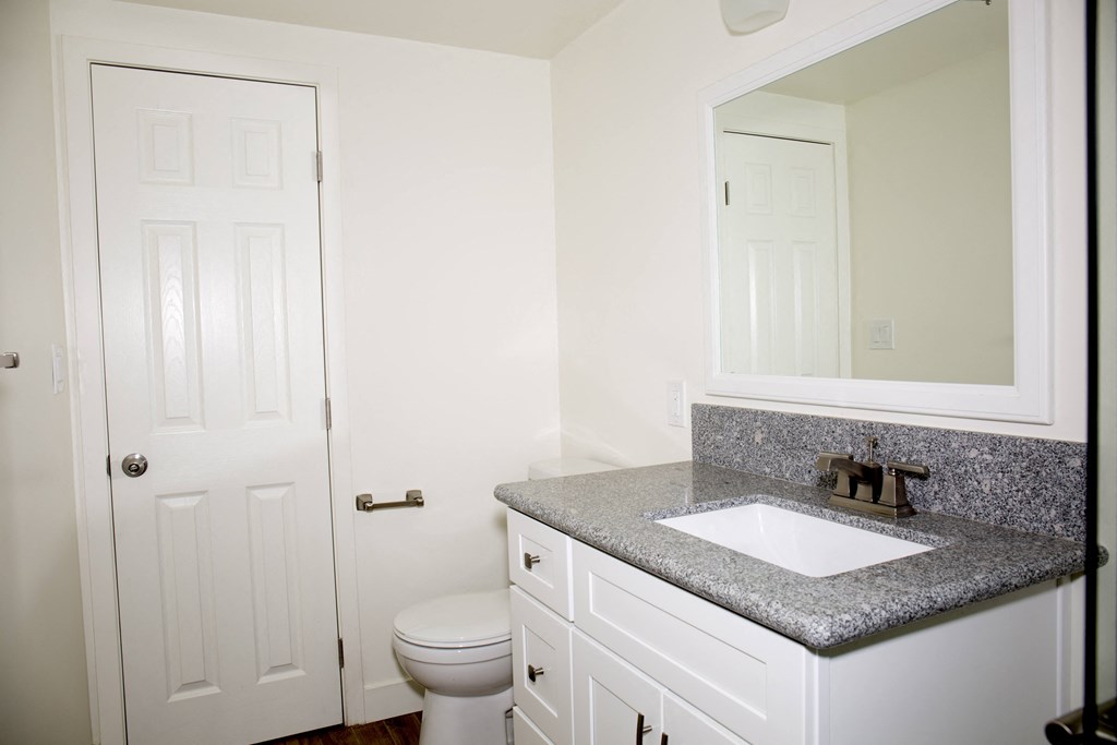 Bathroom with large mirror at Harbor Villa Apartments in San Diego, California.