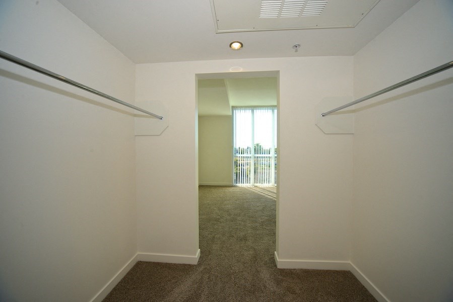 Large walk-in closet in carpeted master bedroom at 12th Street Lofts in National City, California.