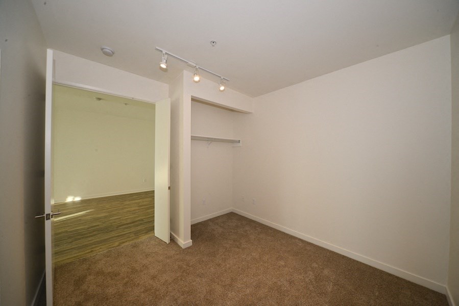 Carpeted bedroom with lots of room to hang clothing at 12th Street Lofts in National City, California.