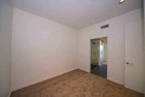 a living room with a carpet and a door to a hallway
