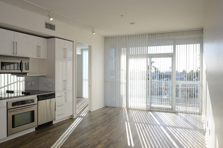 Open living space and door to carpeted bedroom at 12th Street Lofts in National City, California.