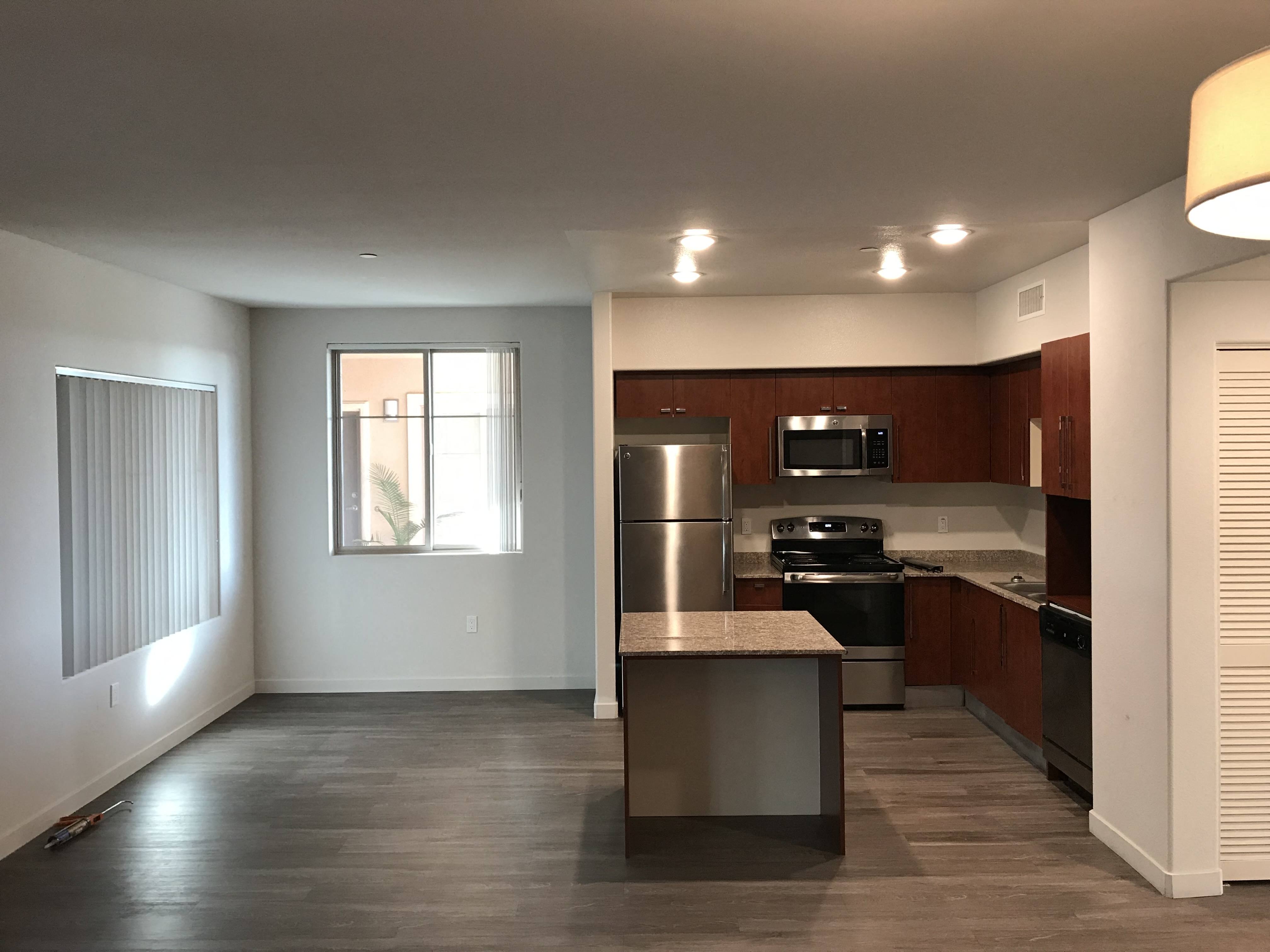Open kitchen and dining room with lots of natural light in apartment at City Plaza Apartments in Escondido, California.