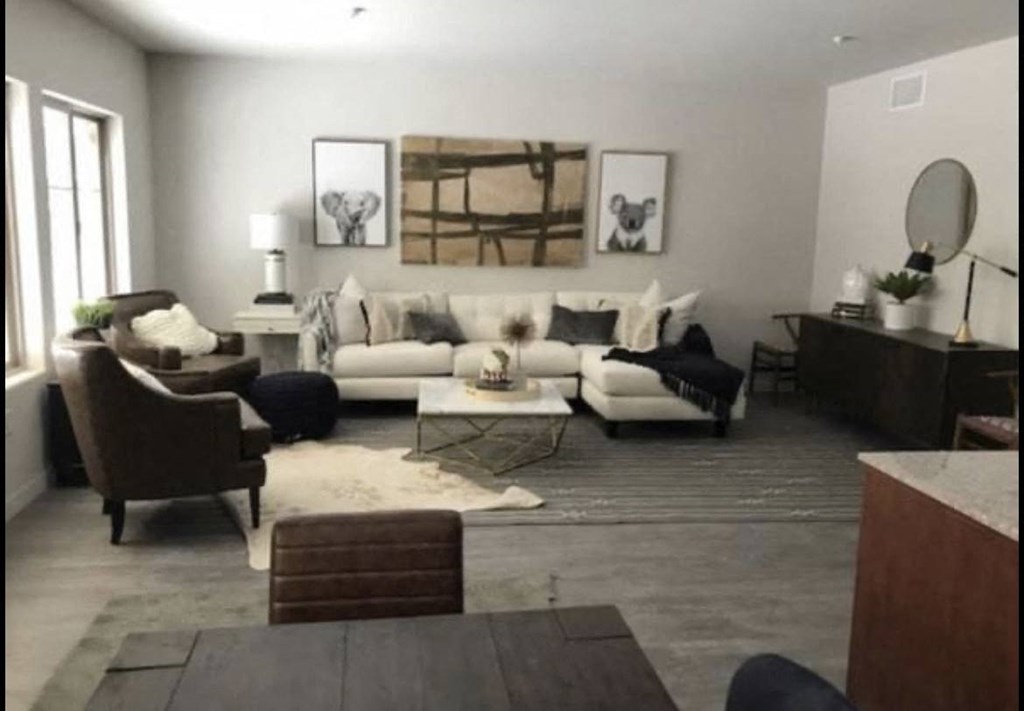 Living room with large windows and plank style flooring at City Plaza Apartments in Escondido, California.